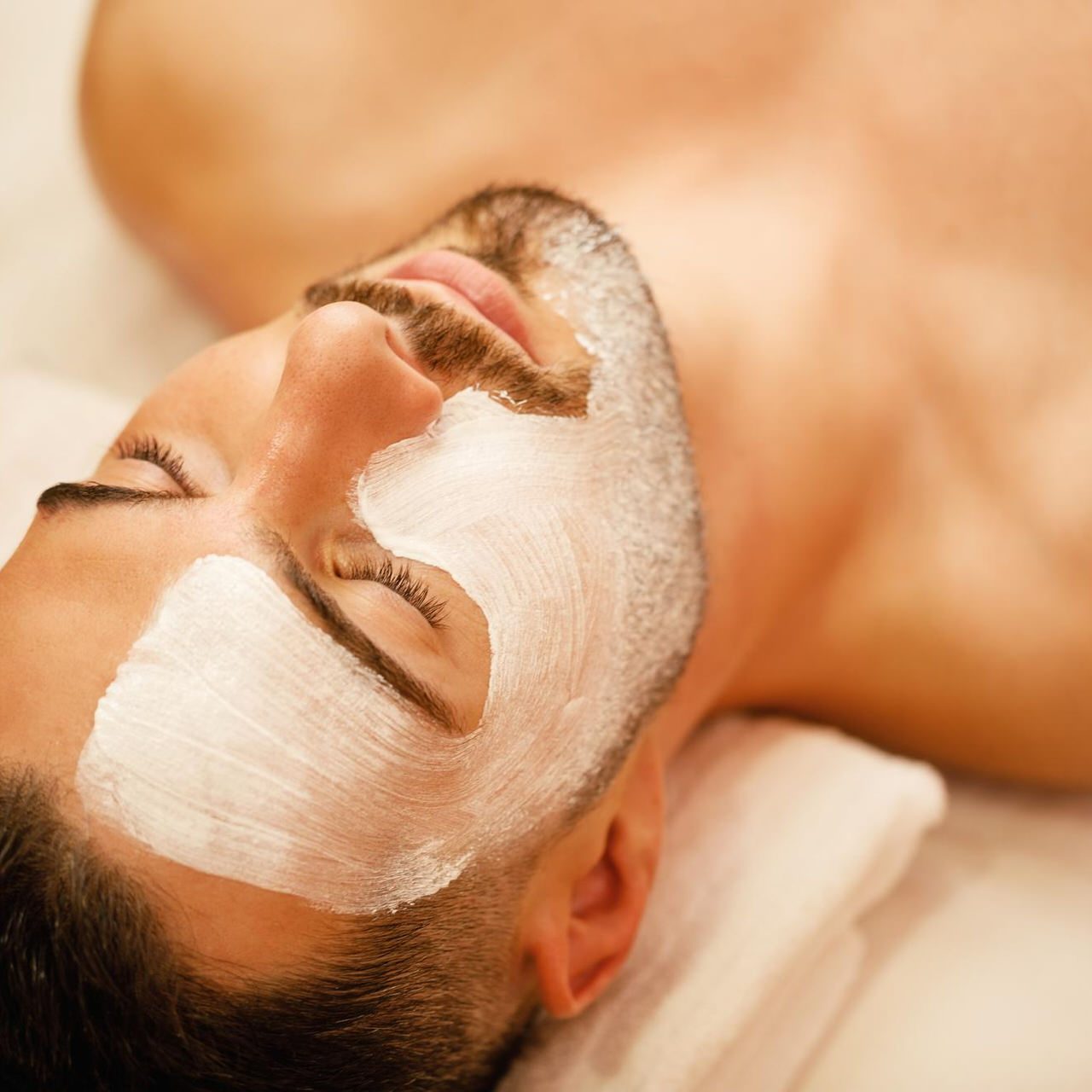 closeup-man-with-white-facial-mask-relaxing-during-treatment-beauty-spa